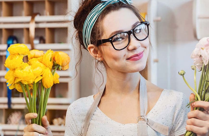 Coral Flowers florist arranging a hand-tied luxury bouquet in the London studio