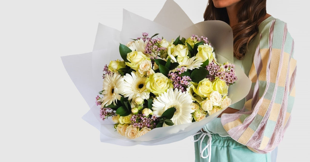 Shine bouquet of ivory roses, white gerberas and pink wax flower by Coral Flowers London
