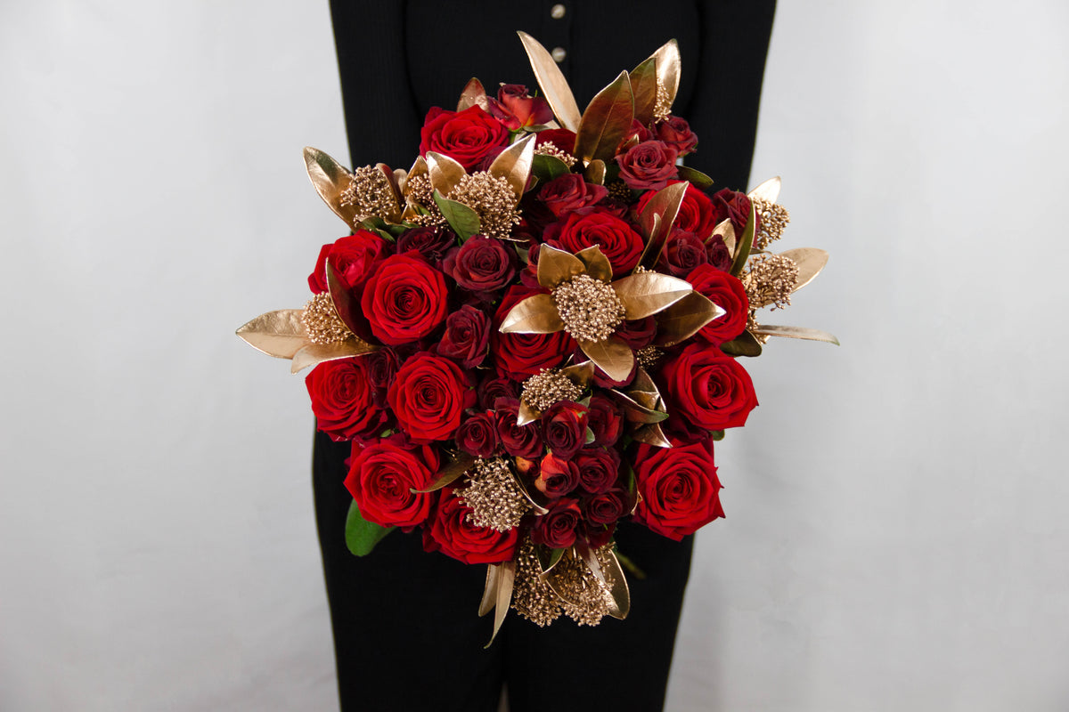 Marigold bouquet of red Naomi roses, red spray roses and skimmia by Coral Flowers London